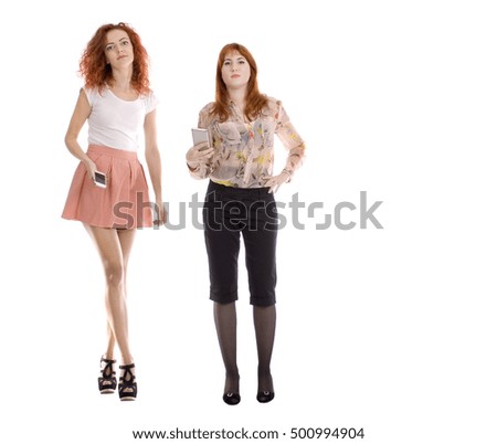 Two young attractive redhead women  with smartphone - studio shot - isolated white - copy space