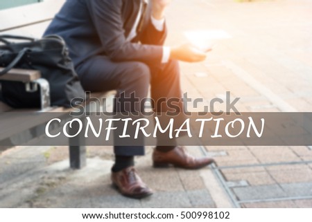Hand writing CONFIRMATION with the young business man on background. Business concept. Stock Photo.