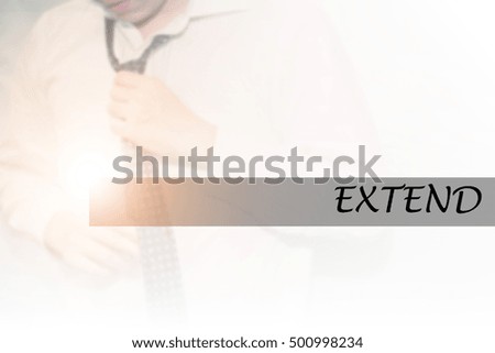 Hand writing EXTEND with the young business man on background. Business concept. Stock Photo.