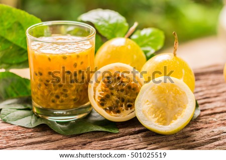 Passion fruits half and juice with leaves on the vintage wooden background. Closeup, Select focus. Royalty-Free Stock Photo #501025519