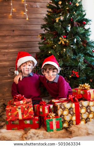 Children under Christmas tree with gift boxes. Xmas presents. 