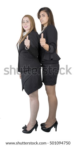 Isolated twins like Egyptian smiling business woman making thumbs up gesture wearing formal (blazer).