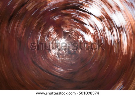 Abstract image of autumn foliage and sunburst made by rotating the camera during exposure.