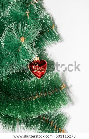 On a white background Christmas-tree branch and displayed on it hanging red with gold rerelivom toy and love inscription