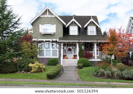 Beautiful upscale house in Canada. Autumn scene, Halloween pumpkins on the porch. 