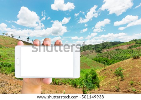 Man use mobile phone , deforested as background.