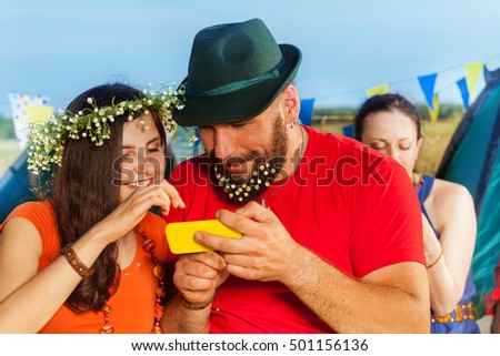 Happy young couple watching pictures at smartphone