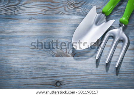 Hand spade trowel fork on wooden board gardening concept.