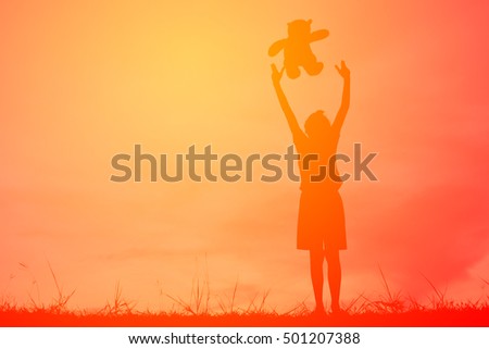 Silhouette a girl with teddy bear on mountain and sky sunset, happy girl in holiday process style vintage tone