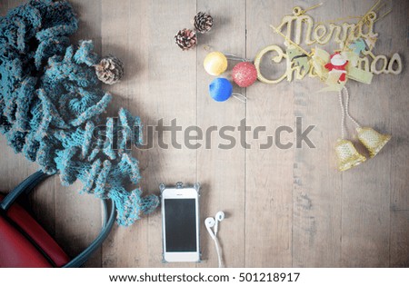 Flat lay of winter scarf, Christmas decoration items and smartphone on wooden background, XMAS, vintage filter