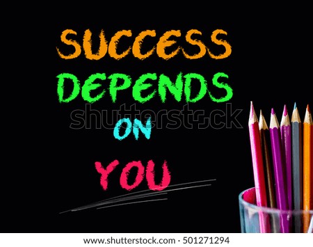 Color pencil on black background with word: SUCCESS DEPENDS ON YOU