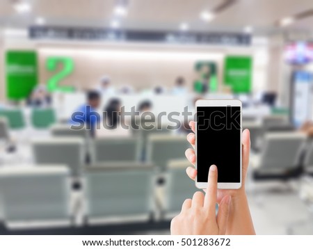 woman use mobile phone and blurred image of hospital lobby