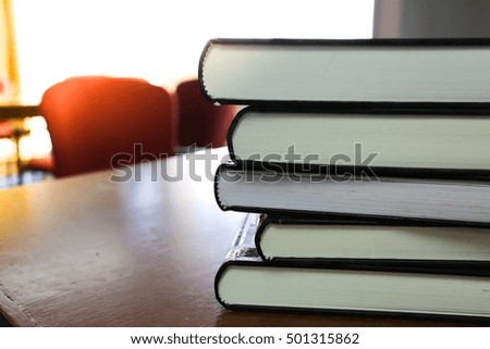stack of books on the wooden table in library. 