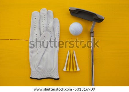Different golf equipments on the yellow desk - flat lay photography