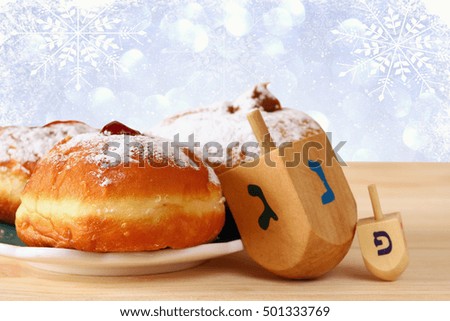 image of jewish holiday Hanukkah with donuts and wooden dreidels (spinning top)