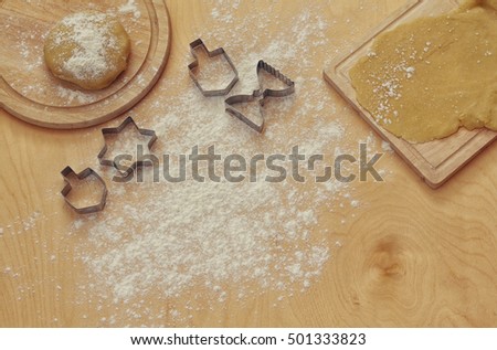 top view image of jewish holiday Hanukkah concept. Baking donuts and cookies on wooden kitchen table