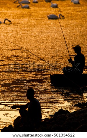 Silhouette of  fisherman  fishing at sunset