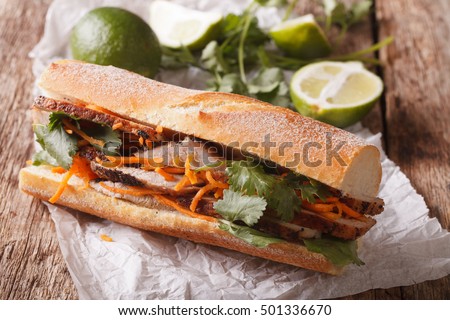 Vietnamese Pork Banh Mi Sandwich with Cilantro and carrot close-up on the table. Horizontal
 Royalty-Free Stock Photo #501336670