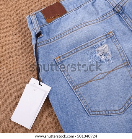 Jeans texture with leather label. on light natural linen texture,
