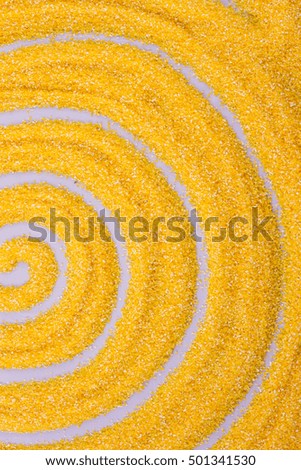 Concentric circles drawn with a finger on corn grits closeup, vertical photo