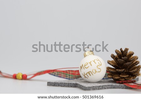 A grey star with a Christmas ball saying Merry Xmas, pine cone and a ribbon