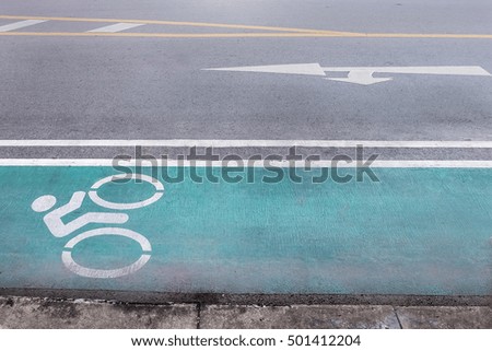 Green bike lane on city street and direction arrow