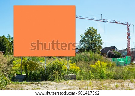 Huge billboard Sign on green grass, blue sky,  construction building crane, village  background , text place

