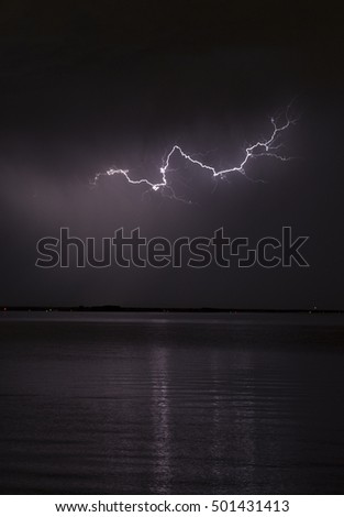 Lightning strike reflecting on the water.
