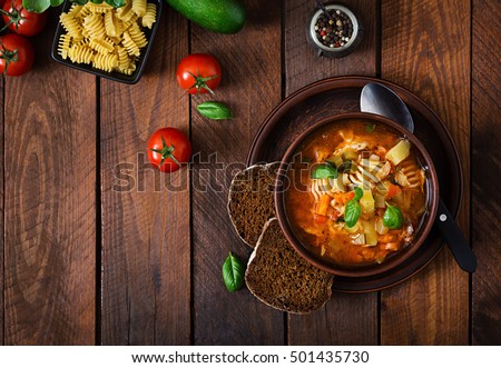 Minestrone, italian vegetable soup with pasta on wooden table. Top view Royalty-Free Stock Photo #501435730