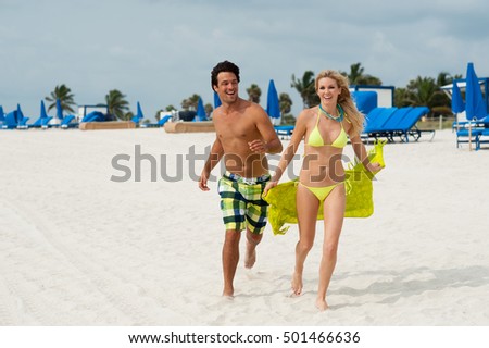 Young Couple Man and Woman Playing Running on Beach