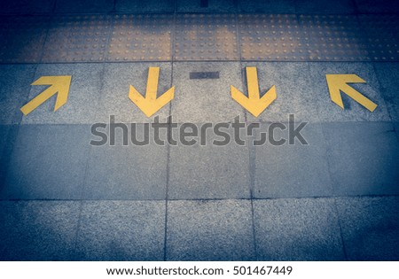 yellow arrow sign on floor at the sky train station vintage filter