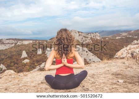 Girl doing yoga in mountains landscape