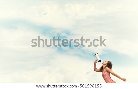 Young woman shouting in megaphone with blue sky background