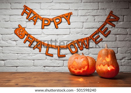 halloween Pumpkin on a wooden table, background brick wall, happy halloween