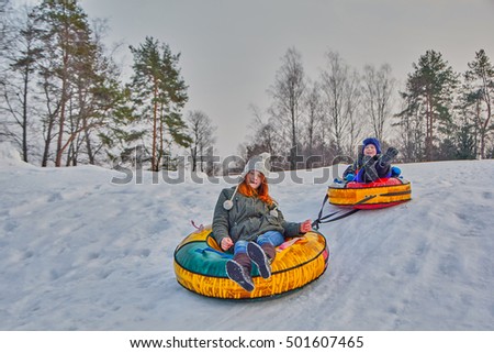 Happy children enjoying a winter sleigh ride on a winter slope