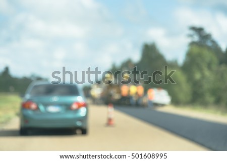 Blurred image traffic on US Highway 59 caused by road construction. Barricades And Large Sewer Pipes and Road closed signs detour traffic temporary. Road construction site work industry background.