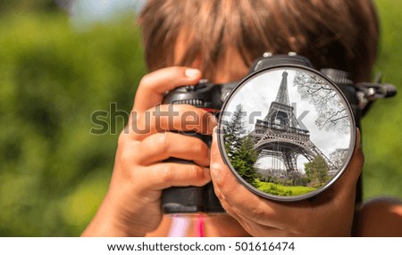 Young girl taking photos of Tour Eiffel by professional digital camera.