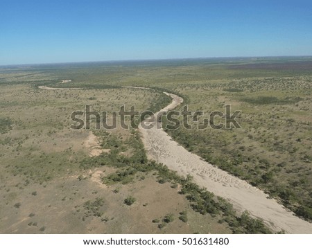 An aerial view of a dry river bed snaking across the desert of Australia's outback.