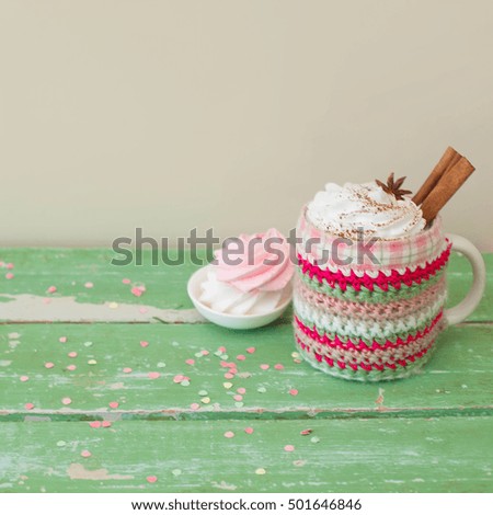 Coffee cappuccino with whipped cream and cinnamon. Pink and white marshmallows. Wood old green.