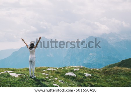 Traveler or hiker with raised arms up in the mountains. Mangart is a mountain in the Julian Alps, located between Italy and Slovenia. Travel, Freedom, Lifestyle concept.