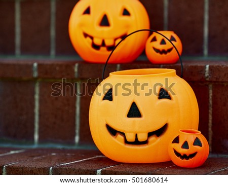 Plastic Halloween pumpkins on brick steps with shallow depth of field