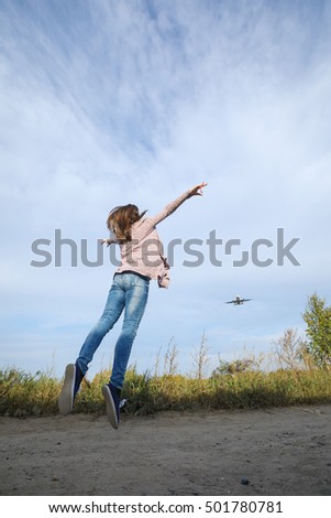 Young beautiful girl jumping happy journey. It looks like a plane taking off from the runway.