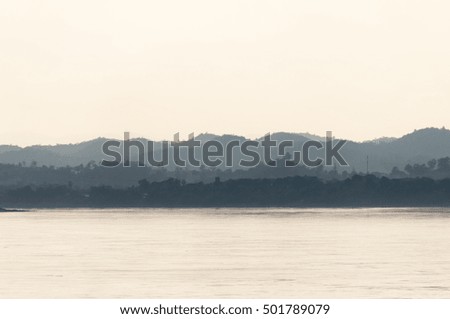 view of mountain and river at evening. subject is blurred and dark light