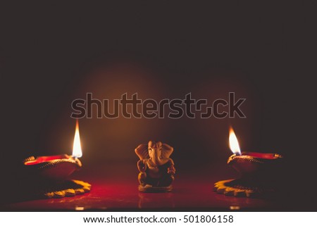 Lord Ganesha & Colorful Diya lamps lit during Diwali celebration