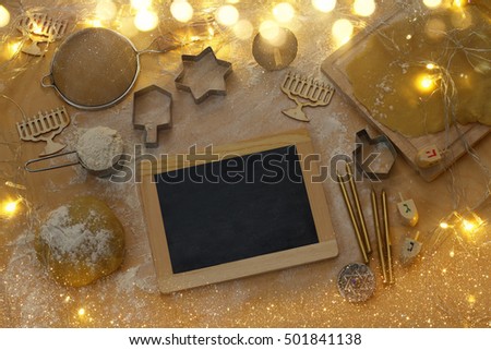 top view image of jewish holiday Hanukkah concept. Baking donuts and cookies on wooden kitchen table