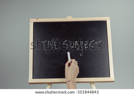 subject written in white chalk on a black chalkboard . gray background