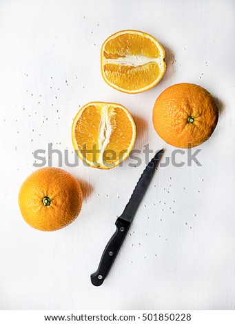 Orange fruit with black knife isolated on white wood background aesthetic picture
