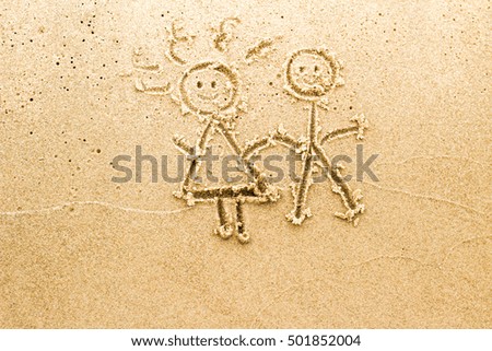 hand drawn image on sand on beach: happy girl and boy