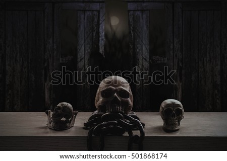 Skulls and chains on old wood with dark at night.