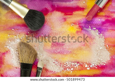 Makeup brushes and lipstick on a vibrant yellow and purple background, with traces of powder and blush. Horizontal template for makeup artist's business card or flyer design, with plenty of copyspace